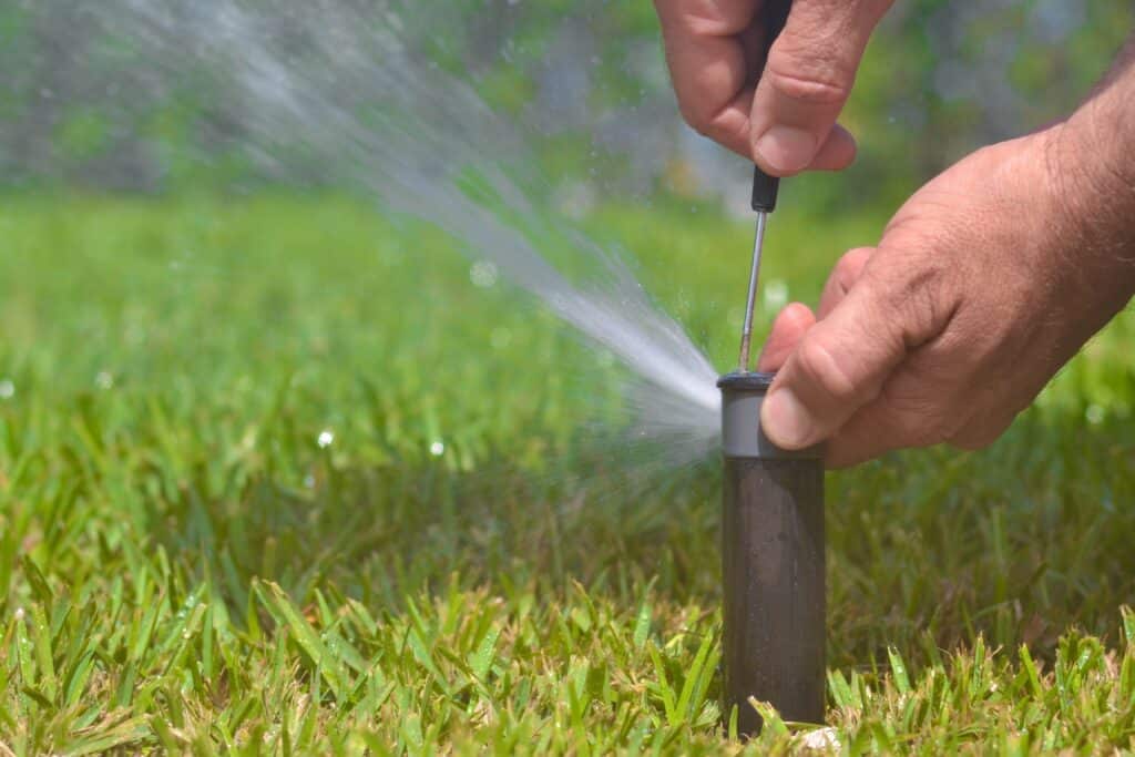 Professional irrigation system check during sprinkler maintenance in Plano